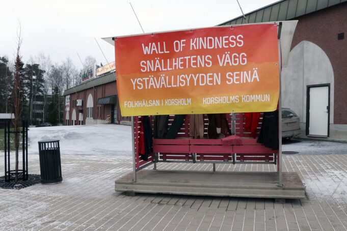 Busskur med text. Linja-autokatos. Text, texti: Wall of kindness, Snällhetens vägg, Ystävällisyyden seinä.