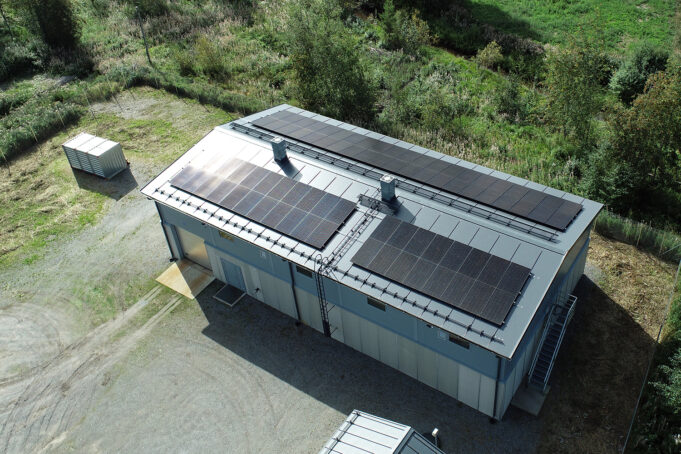 Byggnad med solpaneler. Rakennus jonka katolla aurinkopaneeleja.