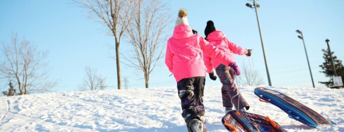Två barn i pulkbacke.