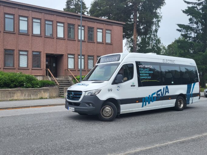 Vit minibuss som kör på gata